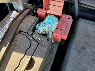 corrosion build-up on positive car battery terminal